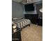 A simple bedroom with a bed, dresser, and a mounted TV for entertainment at 3020 N 64Th Dr, Phoenix, AZ 85033