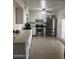 Bright kitchen features stainless steel appliances, white cabinetry and a clean tile floor at 3020 N 64Th Dr, Phoenix, AZ 85033