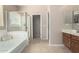 Bathroom featuring a soaking tub and separate glass-enclosed shower at 37852 W Merced St, Maricopa, AZ 85138