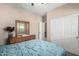 Comfortable bedroom with a dresser, queen bed, mirrored accents, and ample closet space at 37852 W Merced St, Maricopa, AZ 85138
