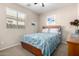 Inviting bedroom with a wooden bed frame, soft blue quilt, and bright natural light at 37852 W Merced St, Maricopa, AZ 85138