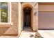 Close-up of front entrance featuring a textured facade, arched doorway, and decorative window at 37852 W Merced St, Maricopa, AZ 85138