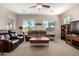 Bright living room with plush seating, large windows, and a ceiling fan at 37852 W Merced St, Maricopa, AZ 85138