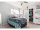 Cozy bedroom with a ceiling fan, closet with white doors, and natural light at 411 N 111Th Pl, Mesa, AZ 85207