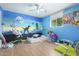 Spacious bedroom featuring colorful mural, ceiling fan, and wood-look flooring at 411 N 111Th Pl, Mesa, AZ 85207