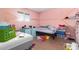 Bedroom with laminate wood flooring, bright pink walls, and natural light at 411 N 111Th Pl, Mesa, AZ 85207