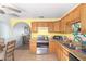 Eat-in kitchen featuring wooden cabinets, granite countertops, and an adjacent dining area at 411 N 111Th Pl, Mesa, AZ 85207