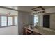 Bathroom with a tile vanity and large mirror open to a spacious carpeted bedroom at 4242 W Sandra Ter, Phoenix, AZ 85053