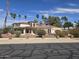 Elegant home featuring a red tile roof, lush landscaping, and a secure brick and wrought iron fence at 4242 W Sandra Ter, Phoenix, AZ 85053