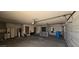 A spacious garage featuring an automatic garage door, storage cabinets and a blue recycle bin at 4242 W Sandra Ter, Phoenix, AZ 85053