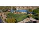 This aerial view showcases a park, lush green lawns, a playground, and mature trees creating a great outdoor space at 42430 W Oakland Dr, Maricopa, AZ 85138