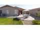 Enjoy outdoor dining on the patio in this landscaped backyard featuring green grass and desert accents at 42430 W Oakland Dr, Maricopa, AZ 85138