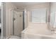This bright bathroom has a tiled shower, soaking tub with a window view at 42430 W Oakland Dr, Maricopa, AZ 85138