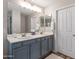 Bathroom featuring a double vanity with updated lighting, framed mirror, and painted cabinets at 42430 W Oakland Dr, Maricopa, AZ 85138