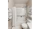 Bathroom with accessible shower-tub combination featuring white shower curtain, hardware, and grab bar at 42430 W Oakland Dr, Maricopa, AZ 85138