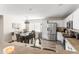 Open kitchen with stainless steel appliances, white cabinets, and an adjacent dining area at 42430 W Oakland Dr, Maricopa, AZ 85138