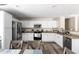 Modern kitchen features white cabinets, stainless steel appliances, and wood-look flooring at 42430 W Oakland Dr, Maricopa, AZ 85138