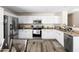 Modern kitchen featuring white cabinets, stainless steel appliances, and stylish flooring at 42430 W Oakland Dr, Maricopa, AZ 85138