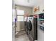 This laundry room offers a window, modern appliances, and shelving for organized storage at 42430 W Oakland Dr, Maricopa, AZ 85138