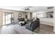 Open-concept living room with sliding glass doors, ceiling fan, and comfortable gray sectional sofa at 42430 W Oakland Dr, Maricopa, AZ 85138