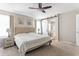 Spacious main bedroom with ceiling fan, ensuite bathroom access via a sliding barn door and neutral décor at 42430 W Oakland Dr, Maricopa, AZ 85138