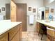 Bathroom featuring tile flooring, wood cabinets and drawers, framed art, and a three-panel mirror above one counter at 425 S Parkcrest -- # 335, Mesa, AZ 85206