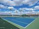 Inviting tennis court with blue surface surrounded by a meticulously maintained net and lush greenery at 425 S Parkcrest -- # 335, Mesa, AZ 85206