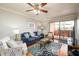 Cozy living room with blue sofa, ceiling fan, and a door leading to the balcony at 4303 E Cactus S Rd # 229, Phoenix, AZ 85032