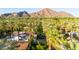 Expansive aerial view showcasing lush palm trees, pristine white roofs, and scenic mountain backdrop at 4420 N 47Th Pl, Phoenix, AZ 85018