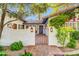 Inviting front entrance with an ornate gate, brick paving, and lush flowering plants, adding charm to the property at 4420 N 47Th Pl, Phoenix, AZ 85018