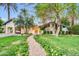 Charming single-story home featuring a brick walkway and beautifully landscaped front yard with mature trees and blooming flowers at 4420 N 47Th Pl, Phoenix, AZ 85018