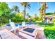 Inviting backyard with a sparkling pool, stylish lounge chairs, and mature palm trees at 4420 N 47Th Pl, Phoenix, AZ 85018