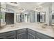 Bathroom featuring dual sinks with a gray cabinet, mirrored backsplash, and ample lighting at 5 W Ranch Rd, Tempe, AZ 85284