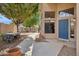Attractive front exterior showcasing desert landscaping, a blue front door, and a cozy outdoor seating area at 5 W Ranch Rd, Tempe, AZ 85284