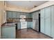 Classic kitchen featuring tile flooring, white appliances, ample cabinet space, and neutral-colored countertops at 5 W Ranch Rd, Tempe, AZ 85284