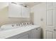 Bright laundry room with front loading washer and dryer and upper storage at 5 W Ranch Rd, Tempe, AZ 85284