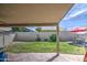 Covered patio featuring a concrete slab, privacy wall, well-maintained lawn, and an outdoor dining area at 515 S Apache Dr, Chandler, AZ 85224