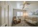 Bedroom with a brown recliner, a gold crib, carpet floors, white walls, and a window with plantation shutters at 515 S Apache Dr, Chandler, AZ 85224