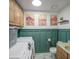 Modern laundry room with light wood cabinets, wainscoting, art, and a front load washer and dryer at 515 S Apache Dr, Chandler, AZ 85224