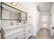 Well-lit bathroom boasting a dual sink vanity, large mirror, and a shower with a curtain at 6130 E Windsor Ave, Scottsdale, AZ 85257