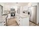 Bright kitchen featuring white cabinets, stainless appliances, a center island, and wood flooring at 6130 E Windsor Ave, Scottsdale, AZ 85257
