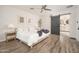Bedroom featuring wood floors, neutral decor, bedside tables, and a barn door to the bathroom at 6130 E Windsor Ave, Scottsdale, AZ 85257