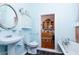 Cozy bathroom with classic fixtures, black tile floor, and view to an organized cabinet at 711 E Mckinley St, Phoenix, AZ 85006