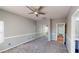 Spacious bedroom with neutral carpet, ceiling fan, and mirrored closet doors at 7730 E Boise St, Mesa, AZ 85207