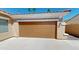 Attached two-car garage has a multi-paneled door, adding convenience and curb appeal at 7730 E Boise St, Mesa, AZ 85207