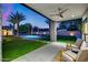 Inviting covered patio overlooking a lush backyard with a sparkling pool at dusk at 12809 N 67Th St, Scottsdale, AZ 85254