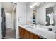 Modern bathroom with a wood vanity, white countertop, and large mirror at 12809 N 67Th St, Scottsdale, AZ 85254
