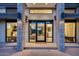 Close view of grand modern home entry with detailed stonework and large glass windows at 12809 N 67Th St, Scottsdale, AZ 85254