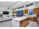 Open-concept kitchen and living area with wood cabinets, island, and access to outdoor patio at 12809 N 67Th St, Scottsdale, AZ 85254