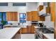 Sleek kitchen with wood cabinets, stainless steel appliances, white countertops, and modern fixtures at 12809 N 67Th St, Scottsdale, AZ 85254